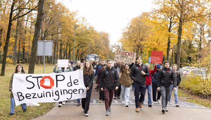 Medewerkers en studenten van de Universiteit Twente lopen een protestmars tegen de bezuinigingen