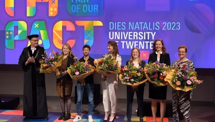 7 people standing in line holding flower bouquets