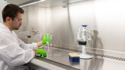 Biomedical engineering student conducts an experiment in the lab using pipettes and laboratory equipment.