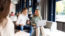 students on couch looking at laptop