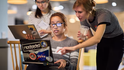 three women looking at a laptop